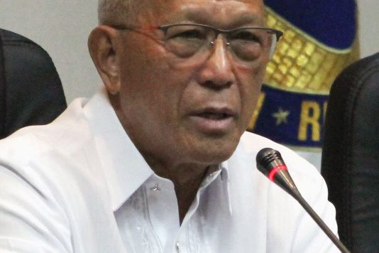 A person speaking into a microphone Description automatically generated