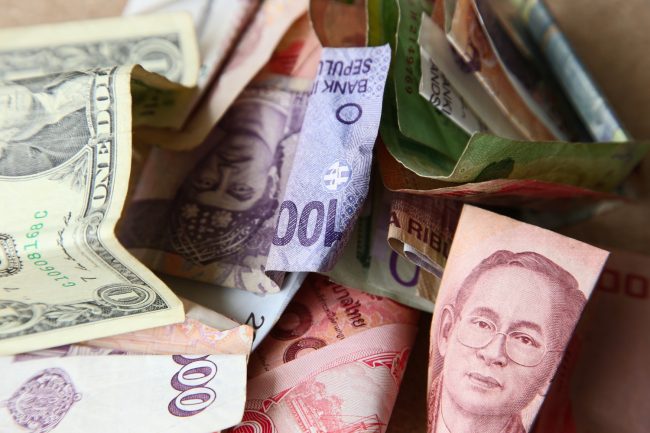 high-angle-shot-pile-banknotes-from-different-countries-wooden-surface